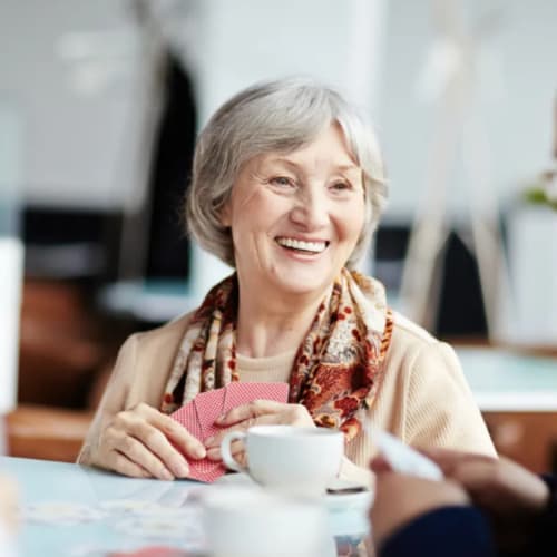 Woman playing cards with friends at Oxford Vista Wichita in Wichita, Kansas