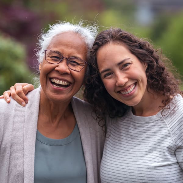 Resident outdoors smiling while embracing her daughter at Pacifica Senior Living Ellensburg in Ellensburg, Washington.
