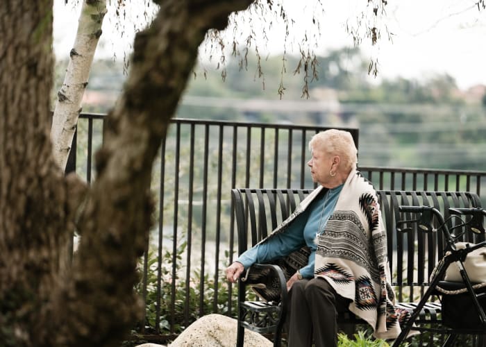 Resident sitting on a bench at The Terraces at Park Marino