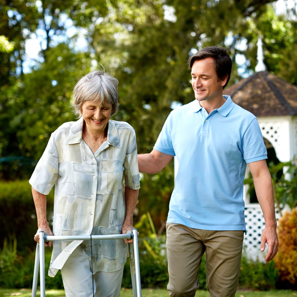 A caregiver and a resident out for a walk at Inspired Living Delray Beach in Delray Beach, Florida