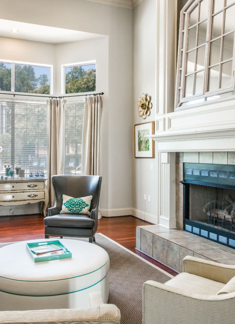 Bright and comfortable sitting area next to fireplace in clubhouse at Marquis at Carmel Commons in Charlotte, North Carolina