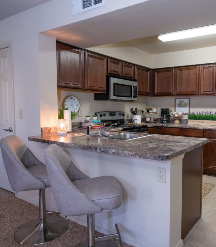 Kitchen with bar seating at Coffee Creek Apartments in Owasso, Oklahoma