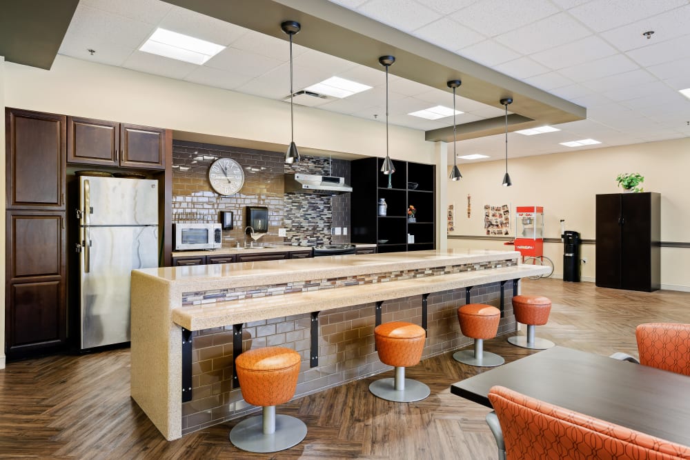 Elegant bar stool seating with kitchen area in back at Anthology of Olathe in Olathe, Kansas