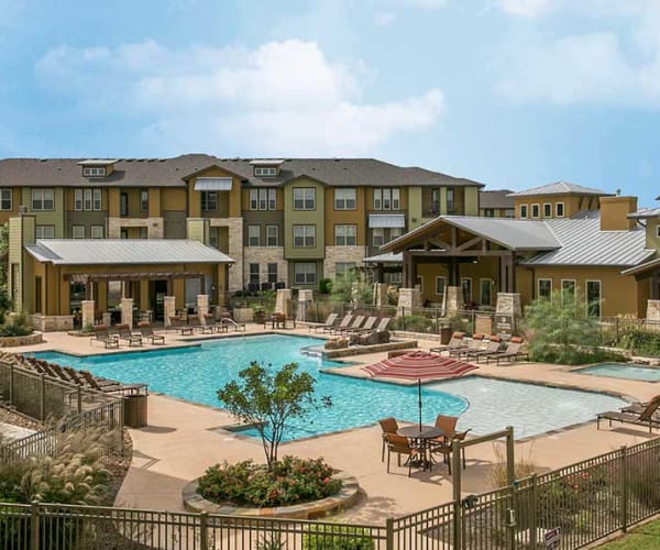 View of Pecos Flats' apartment buildings and pool in San Antonio, Texas
