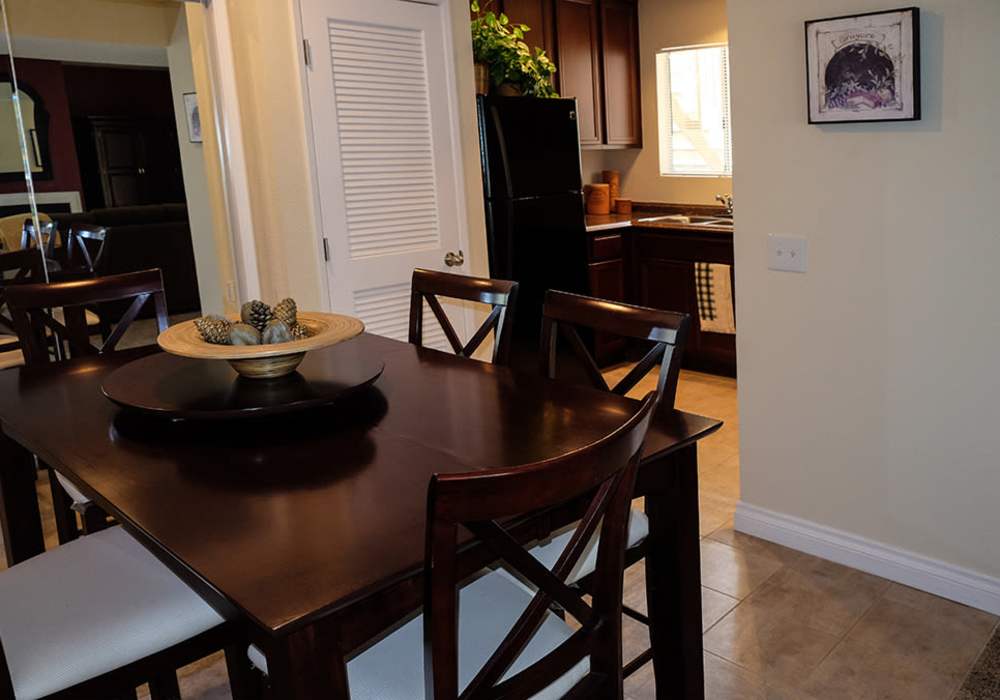 Dining area with chairs and wood flooring at Shadowridge Summerwind in Vista, California