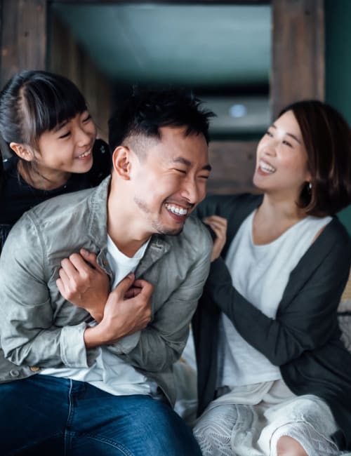 A smiling family in their apartment living room at The Highland Club in Baton Rouge, Louisiana