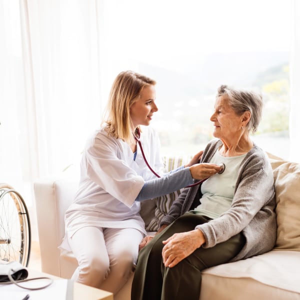 Onsite nurse listening to the heartbeat of a resident at Quail Park of Lynnwood in Lynnwood, Washington