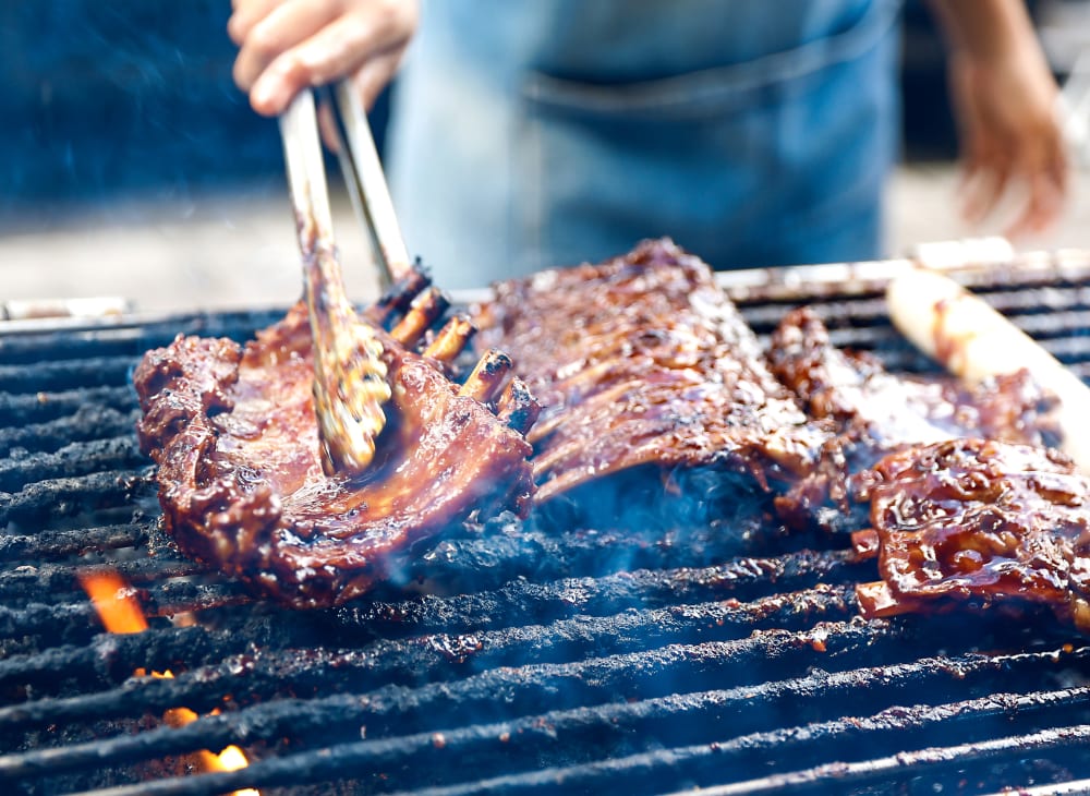 A resident flips a steak at a bbq station at The Hardison in Salt Lake City, Utah