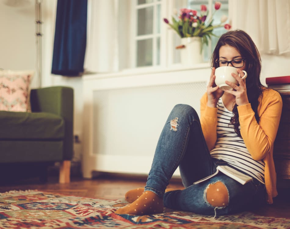 Resident relaxing with a cup of tea in her new home at Vue Issaquah in Issaquah, Washington