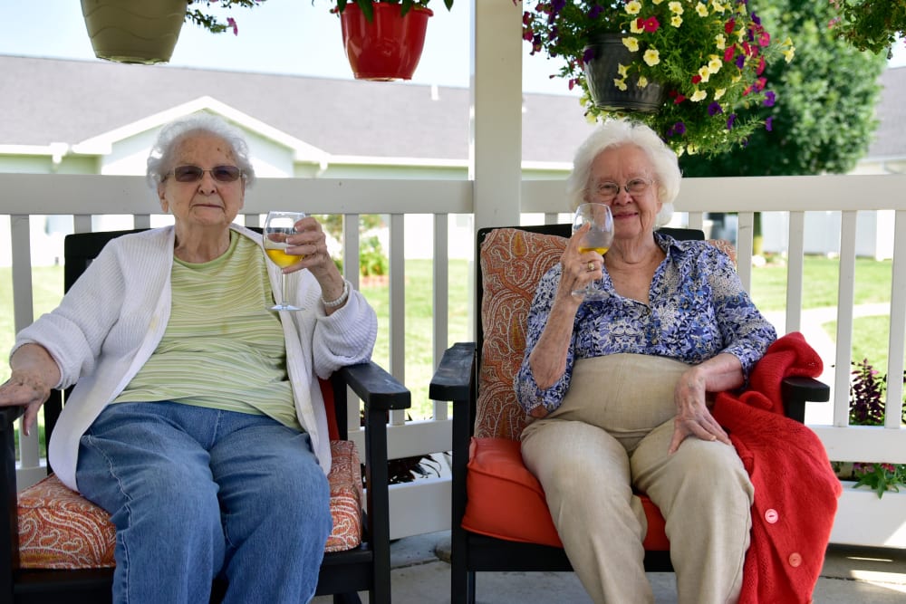 Two residents enjoying sitting on a porch at Garden Place Columbia in Columbia, Illinois. 