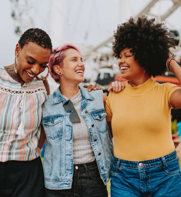 Three women smiling together outdoors near Ardmore & Twenty Eighth in Atlanta, Georgia