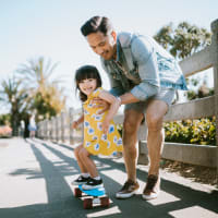 A father helping his daughter ride a skateboard near The Lively Indigo Run in Ladson, South Carolina