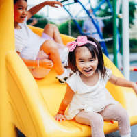 Kid playing on slides at Village at Carlsbad in Carlsbad, New Mexico