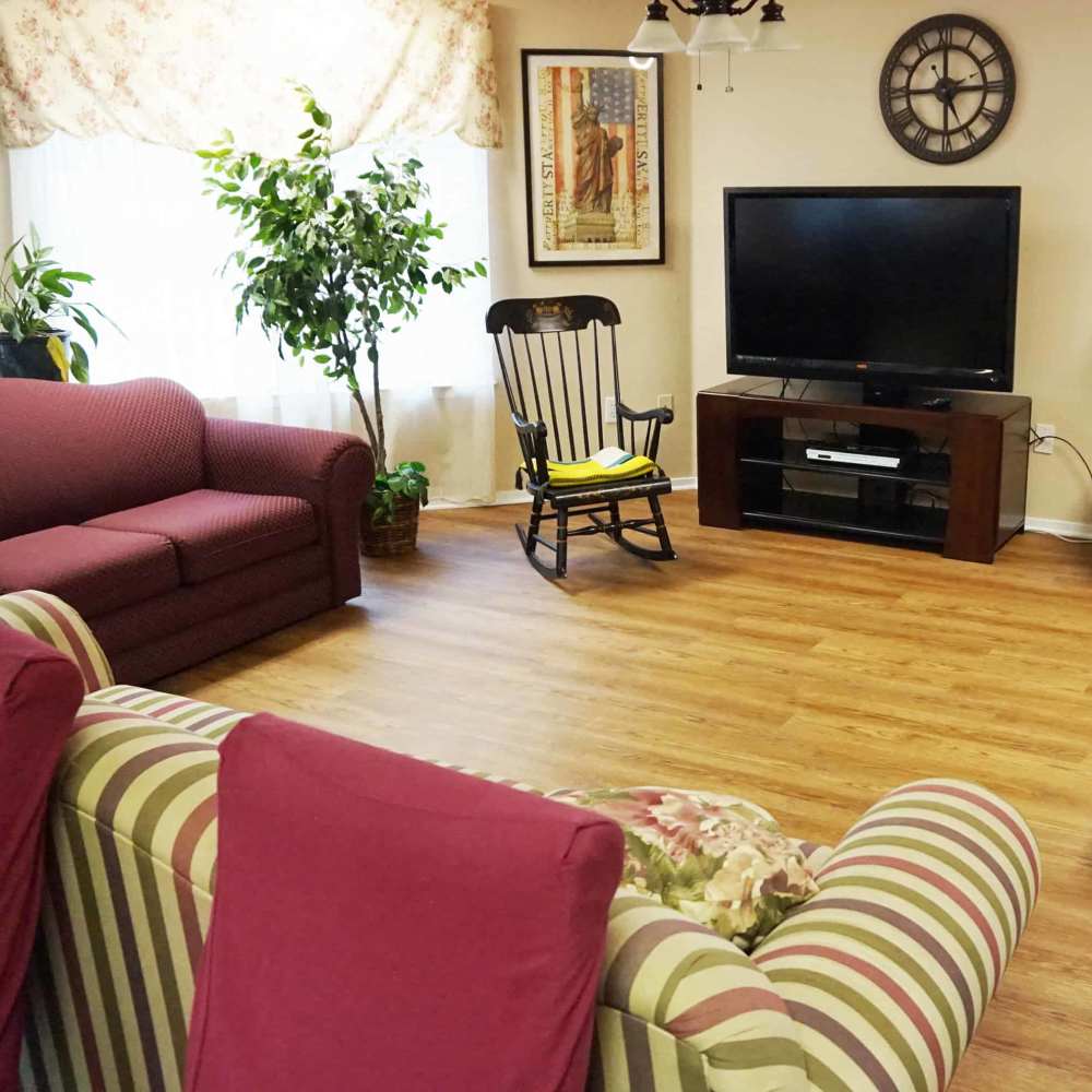 Cozy living room with green plants and comfortable seating at The Parc at Bakers Pointe in Richland Hills, Texas