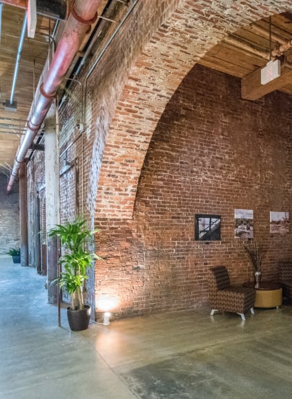 Open floor plan community space with large windows for ample natural light, couch seating and tables at Loray Mill Lofts in Gastonia, North Carolina