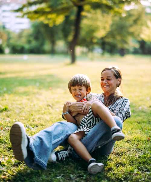 Person playing with child outdoors at Pleasant View Townhomes in Baltimore, Maryland