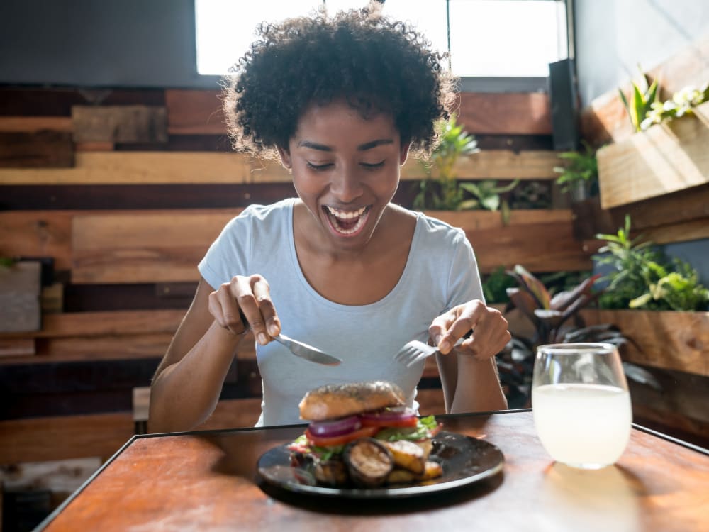 Resident enjoying her burger at a restaurant near Borrego at Spectrum in Gilbert, Arizona