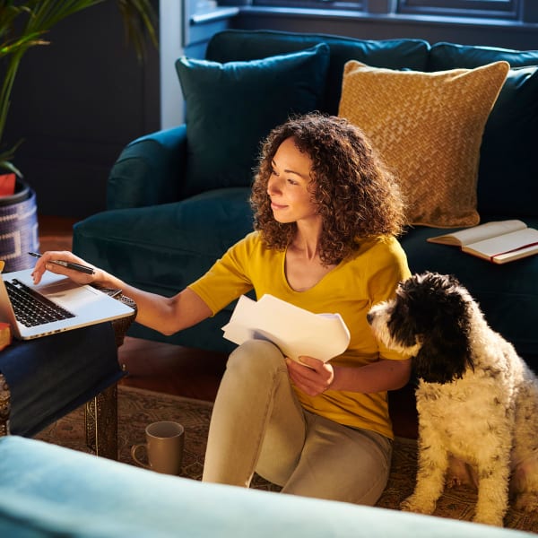 A resident works while her dog sits next to her at Attain Downtown, Norfolk, Virginia