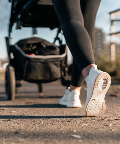 A resident pushing a stroller at a park near The Aubrey in Tempe, Arizona