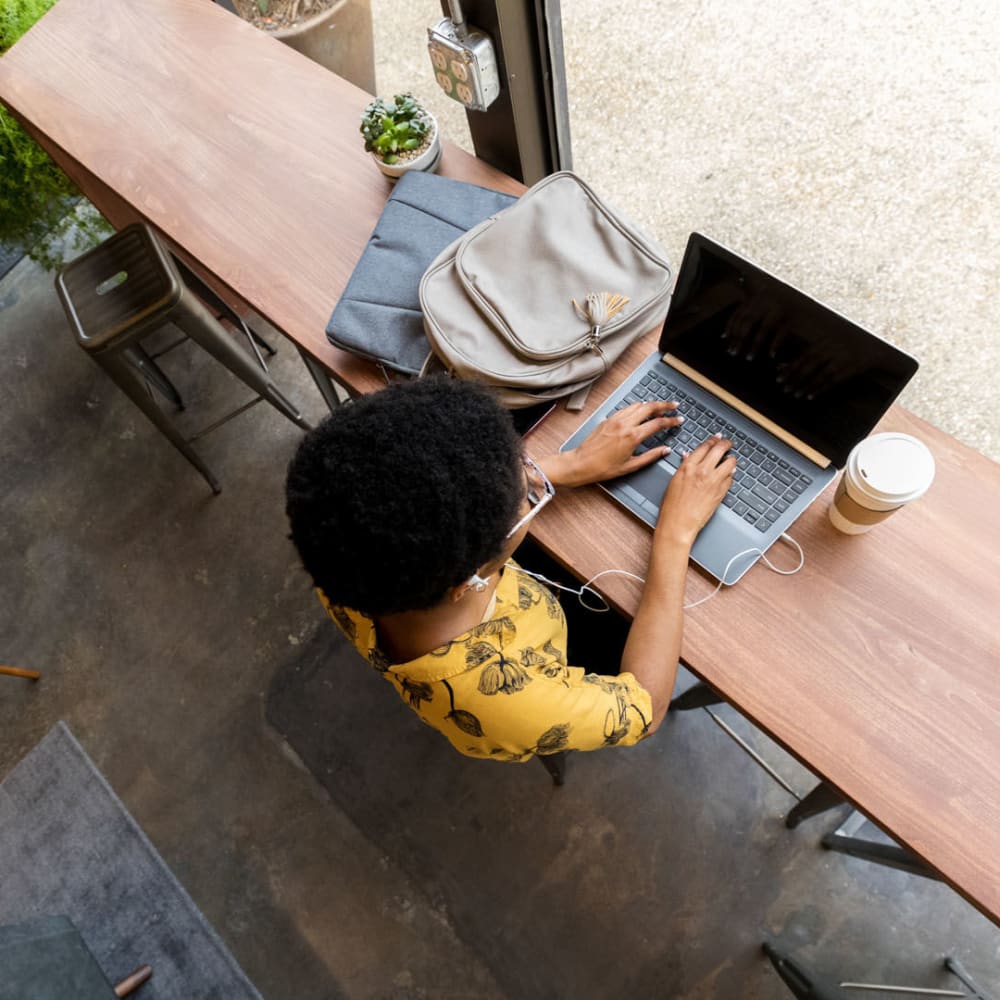 Resident getting some work done on her laptop at a café near Oaks Hackberry Creek in Las Colinas, Texas