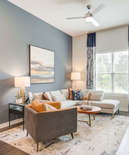 Living room with couch, coffee table and wall painting at The Edison Sugarloaf in Lawrenceville, Georgia
