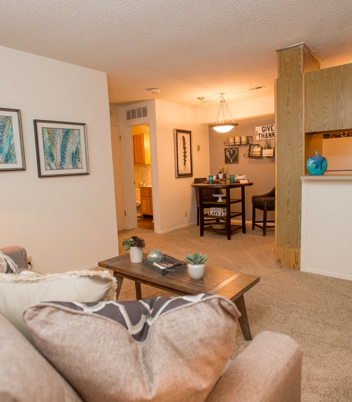 Carpeted living room and kitchen bar at Tammaron Village Apartments in Oklahoma City, Oklahoma