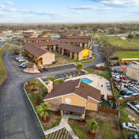 Aerial view of apartment community with parking, pool area, and landscaped grounds at Towne East Village Apartment Homes in Converse, Texas