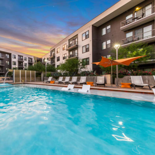 Pool with water feature at end at sunset at Marq Uptown in Austin, Texas