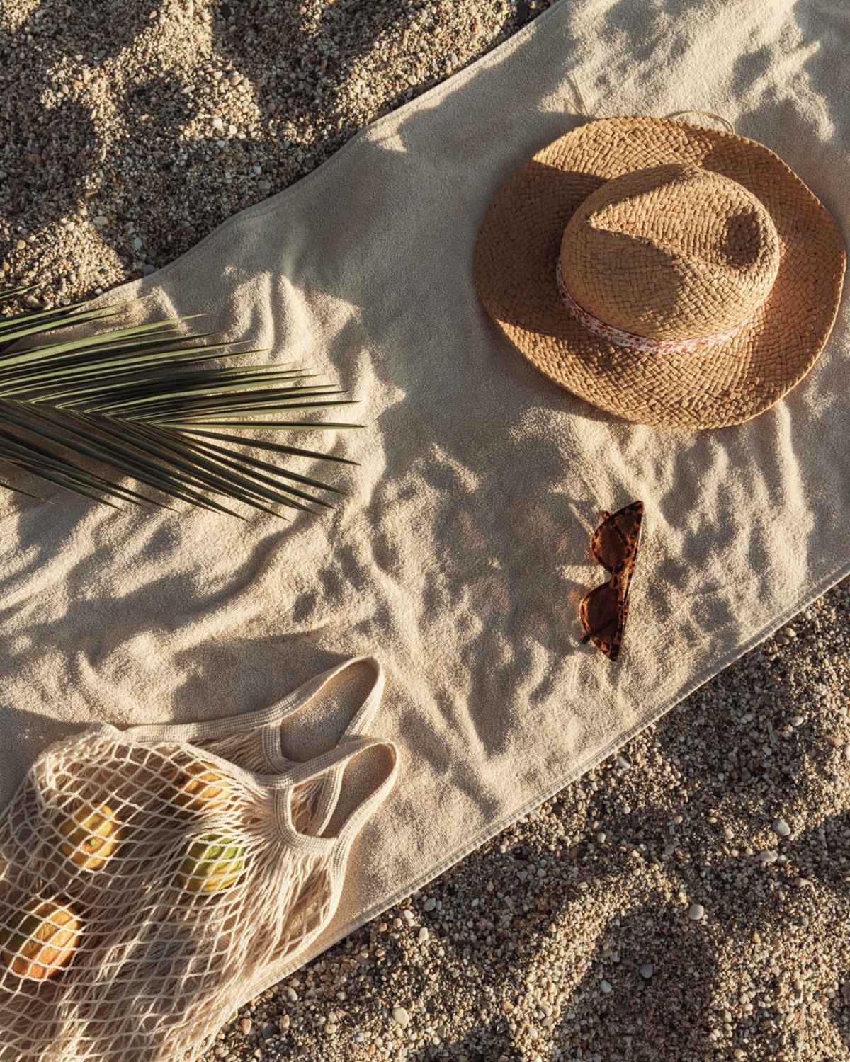 A towel with had and produce laying in the sand near The Current Apartments in Biloxi, Mississippi