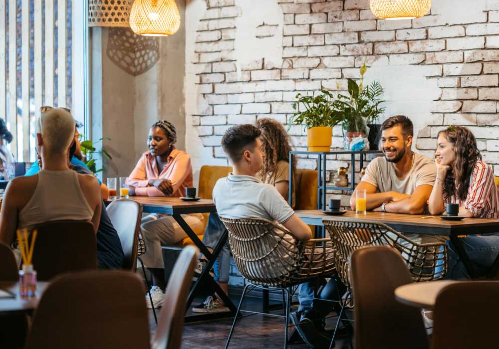 People seated at tables inside a neighborhood café near Unionville Station Townhomes in Hilton, New York