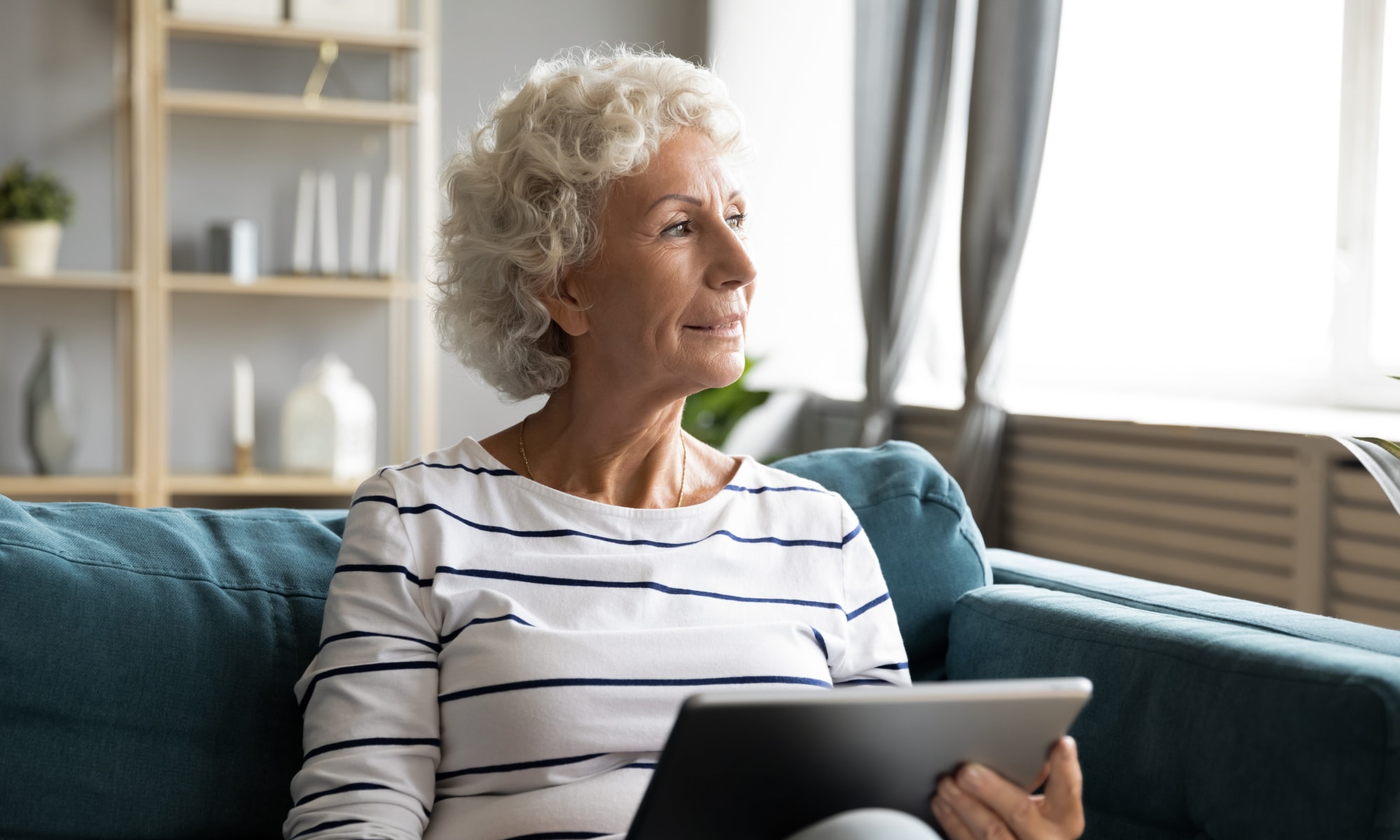 A woman in her living room on a computer at Broadwell Senior Living in Plymouth, Minnesota