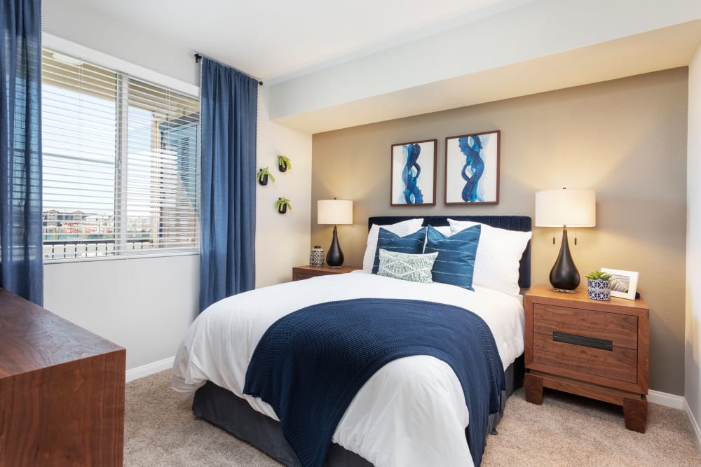 Furnished bedroom with a window overlooking the community at Azure Apartment Homes in Santa Maria, California