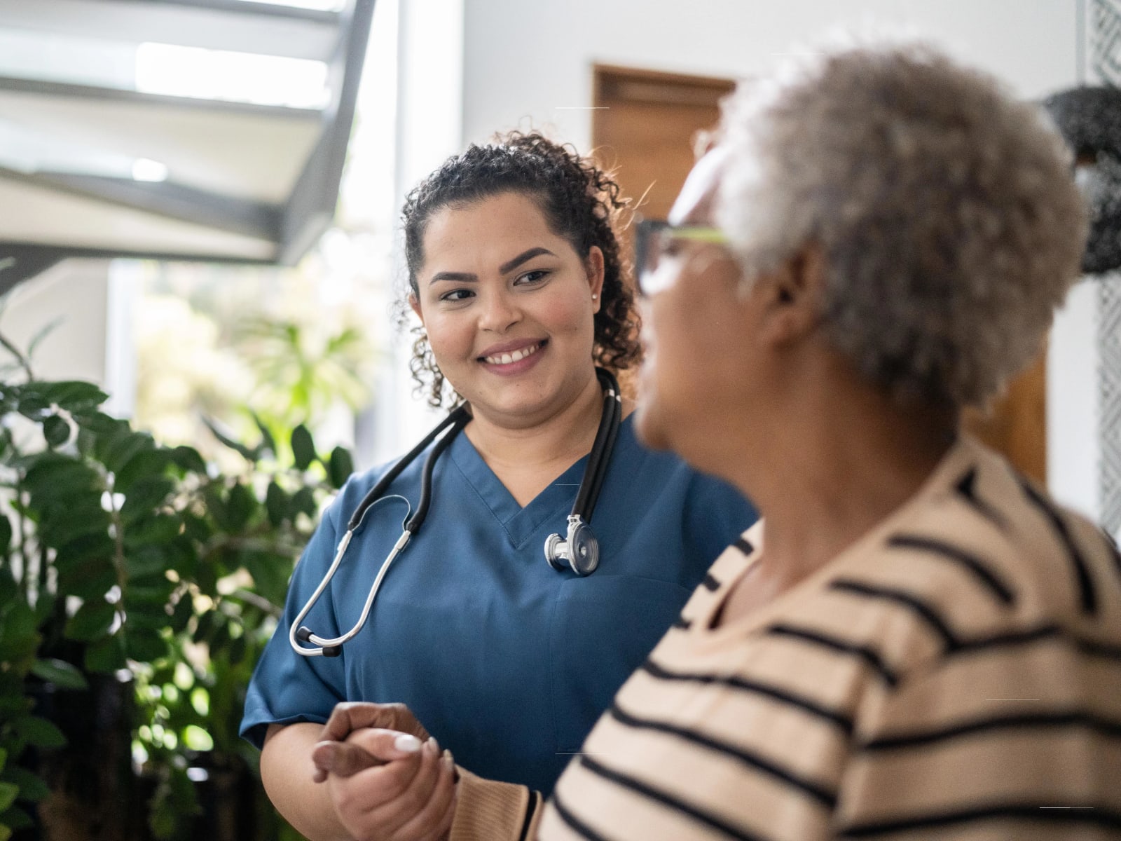 Resident walking with a nurse at Carriage Inn Katy in Katy, Texas