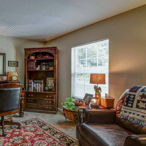 Living room with carpet flooring at Oak Valley Gardens in Glenville, West Virginia