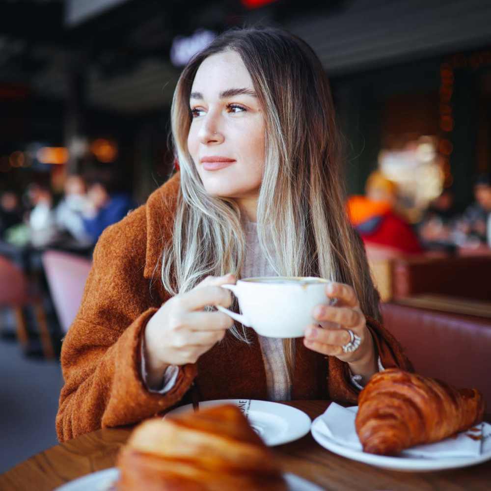 Woman having coffee at a cafe near Vue 3600 in Richmond, California