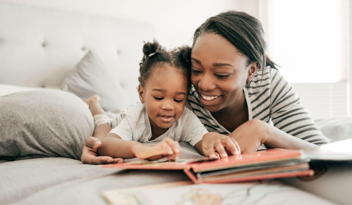 Woman with daughter reading at Belle Vista Apartments in Lithonia, Georgia