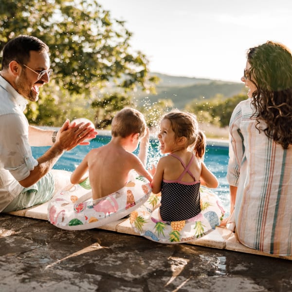 A family sits poolside at Promenade Pointe, Norfolk, Virginia