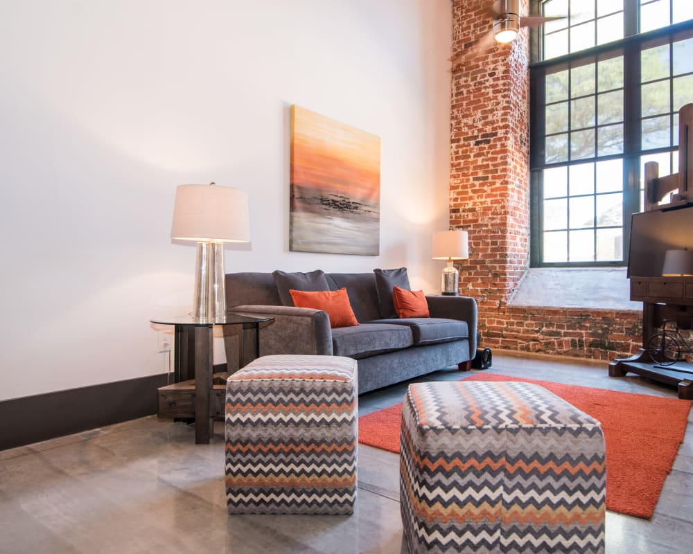 Community clubhouse interior with large windows couch seating and community tables at Loray Mill Lofts in Gastonia, North Carolina