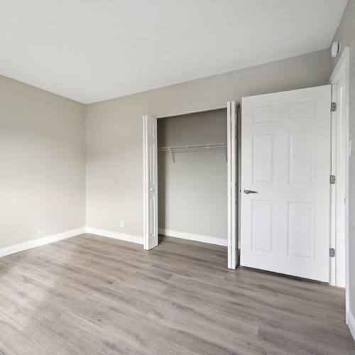 Bedroom with wooden flooring and closet at Charleston Square Apartments in Columbus, Indiana