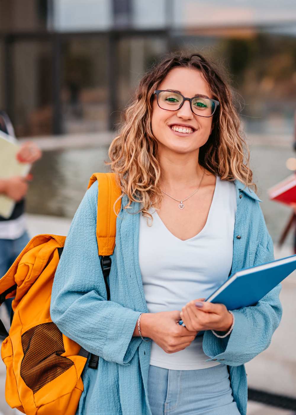 A resident student carrying a binder near Elevate in Englewood, Colorado 