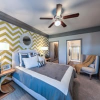 Large bedroom with oversized chair and bed at Waterstone at Cinco Ranch in Katy, Texas