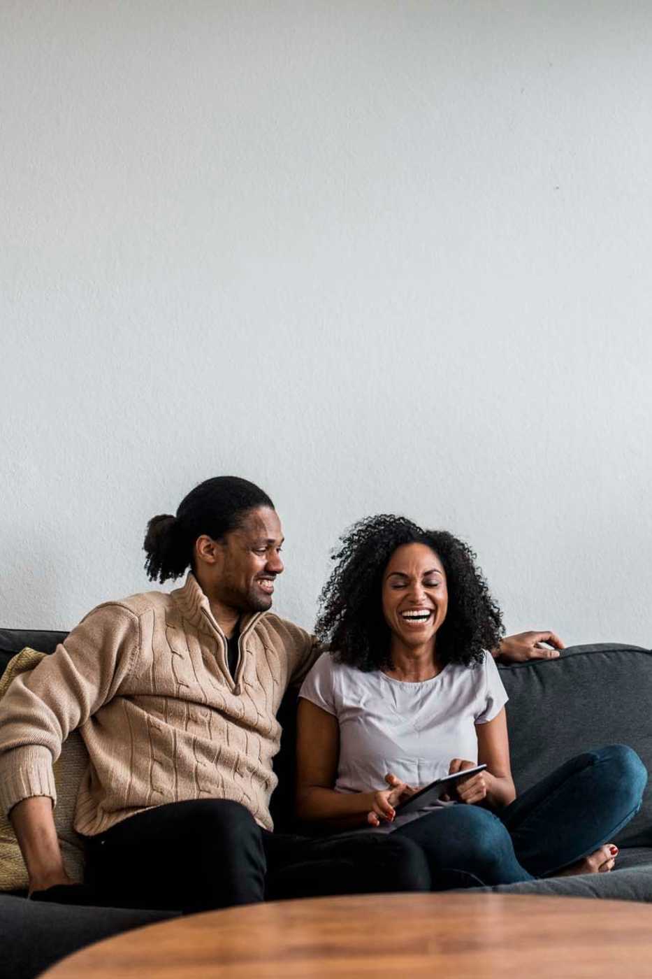 Couple relaxing on the couch in their new home at Falcon Crest Apartments in Louisville, Kentucky