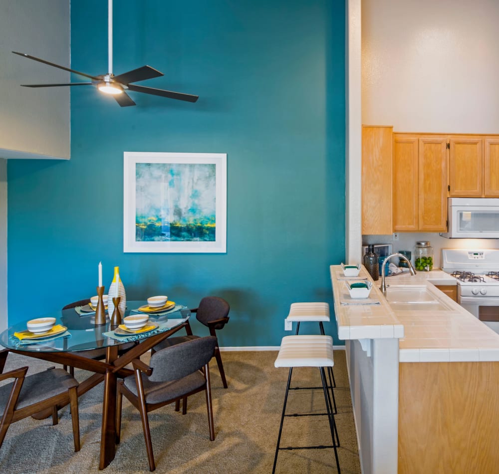 Split view of the dining and kitchen areas from the living space of a model home at Sofi Canyon Hills in San Diego, California