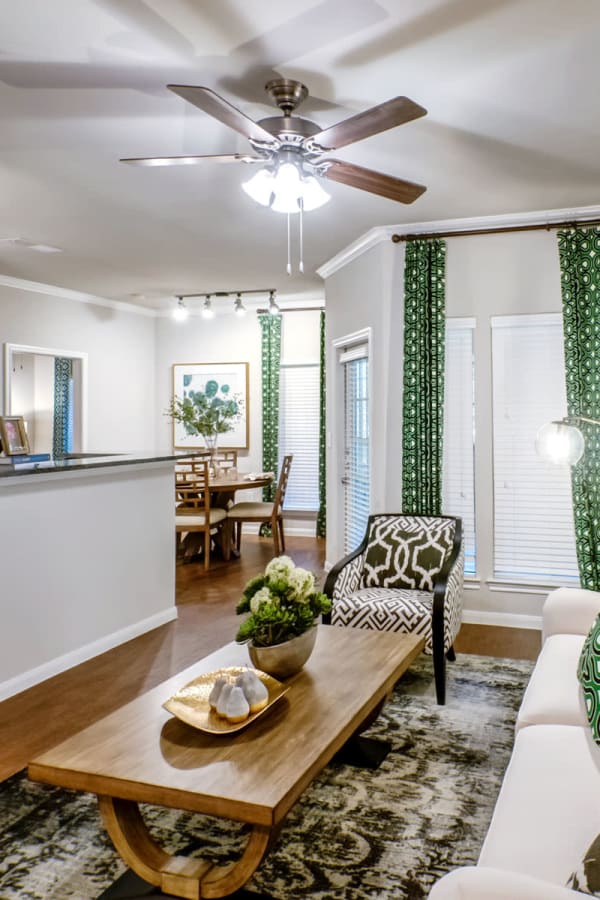 Well-furnished living area with a ceiling fan in a model home at Sonterra Heights in San Antonio, Texas