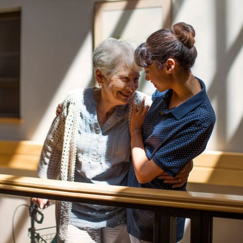 Resident embracing a caretaker at Oxford Springs Tulsa Memory Care in Tulsa, Oklahoma