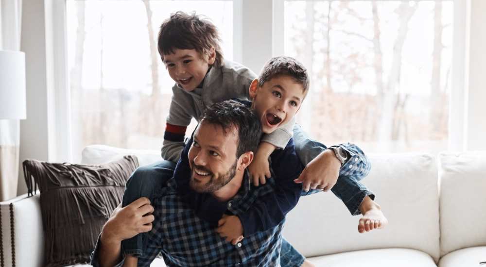 Resident enjoying his time with his sons in a living room at Grandview South Homes in Pittsburgh, Pennsylvania