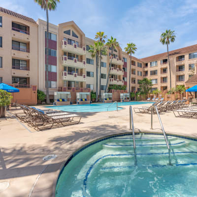 A sunny courtyard with a lovely hot tub and large swimming pool on a beautiful day at Veranda La Jolla in San Diego, California