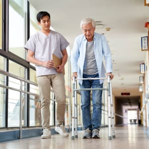 Caretaker helping a resident with walking at Windsor House Corporate in Girard, Ohio
