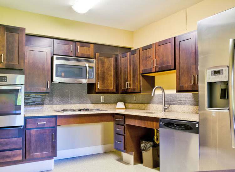 Fully equipped kitchen with appliances and wooden cabinetry at Borden Place Apartments in Fall River, Massachusetts