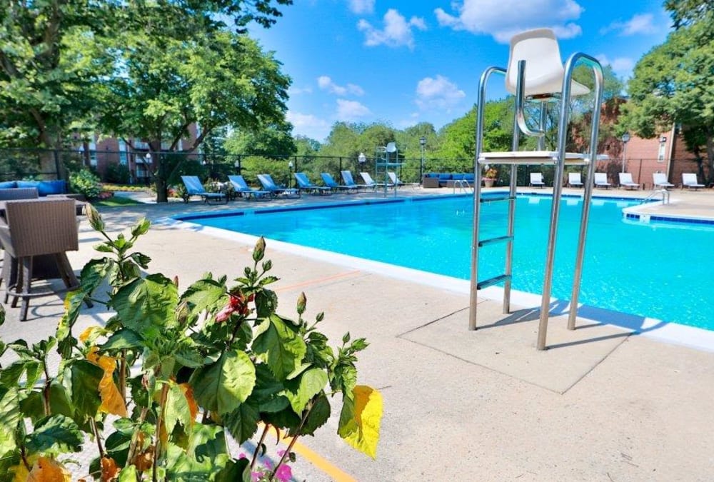 Sparkling swimming pool with poolside lounge chairs at Stoneridge at Mark Center Apartment Homes in Alexandria, Virginia